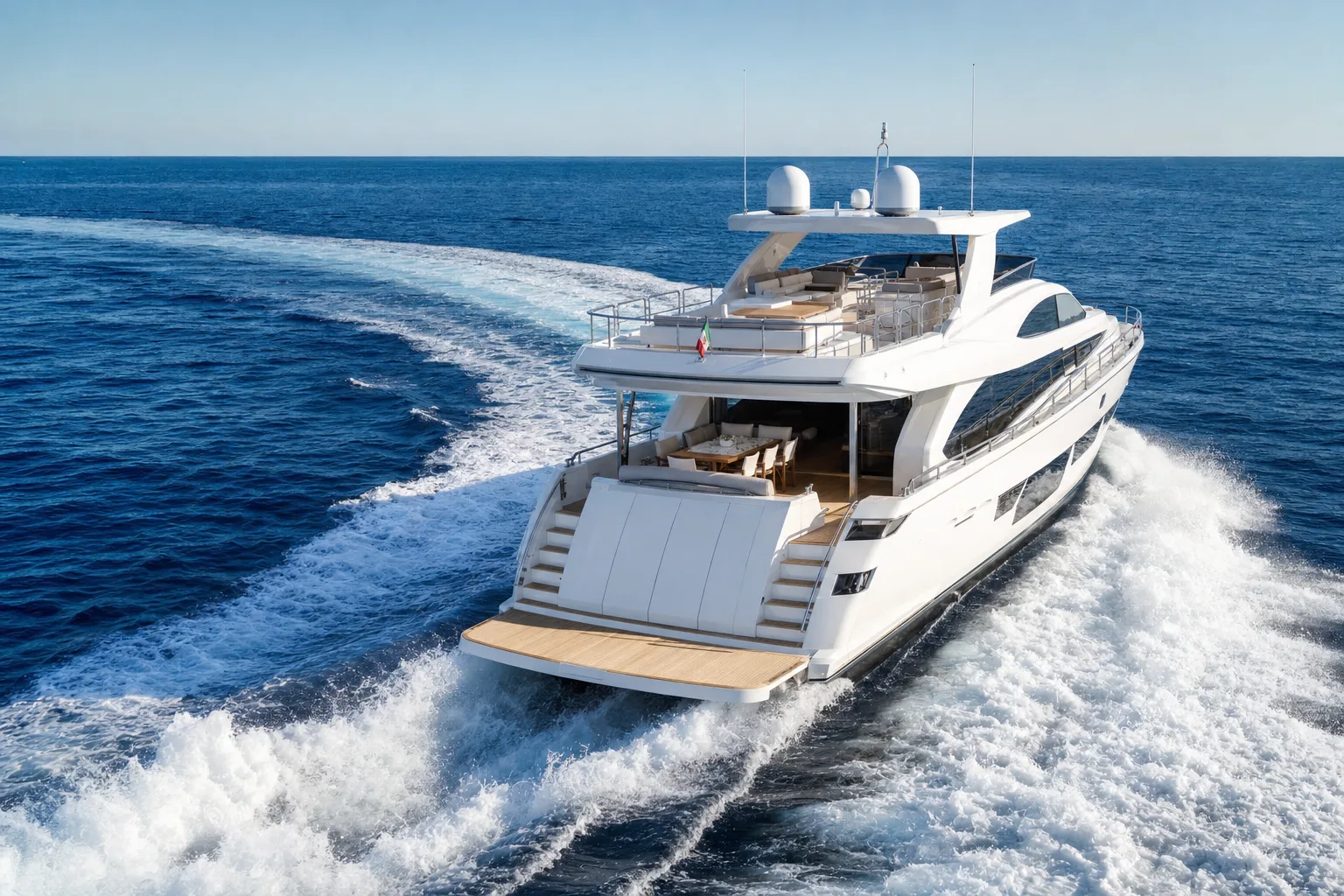A large motor yacht under way on open water leaving a long wake